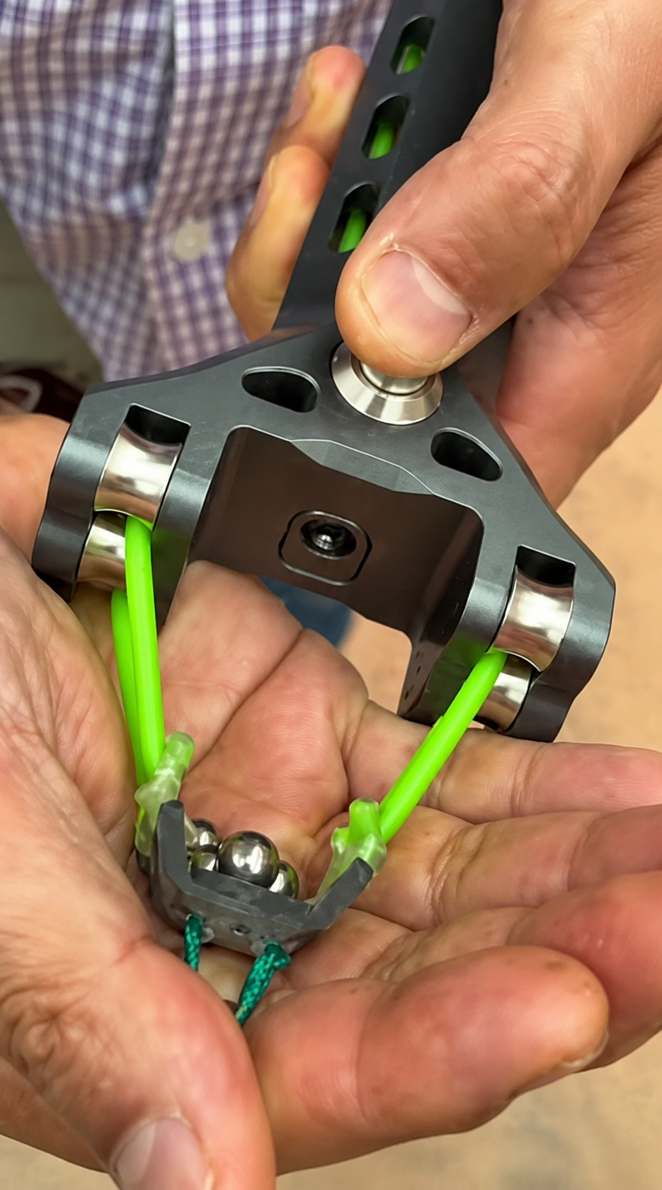Cliente utilizando o APEX PRECISION™ em close com esferas metálicas na mão