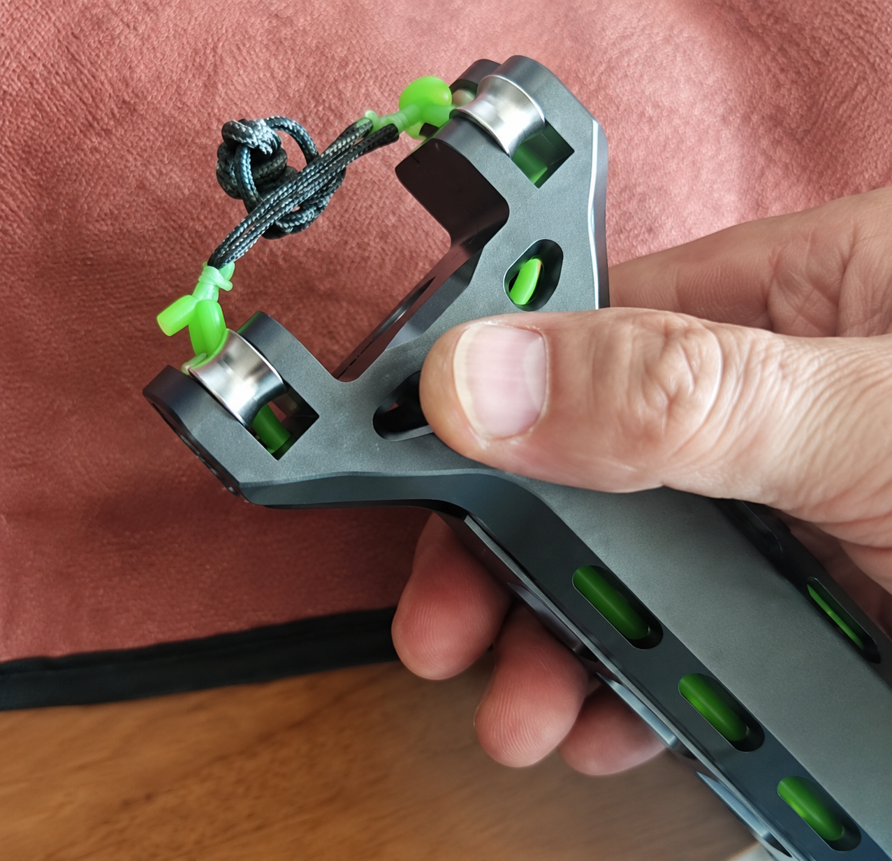 Cliente mostrando o APEX PRECISION™ em close com detalhes verdes e acabamento em alumínio